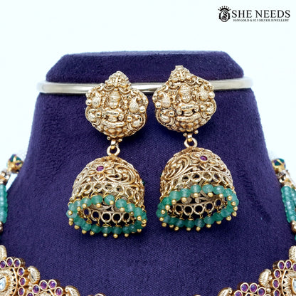 Temple gold Lakshmi choker set with emerald green beads and matching jhumka earrings by She Needs Jewellery