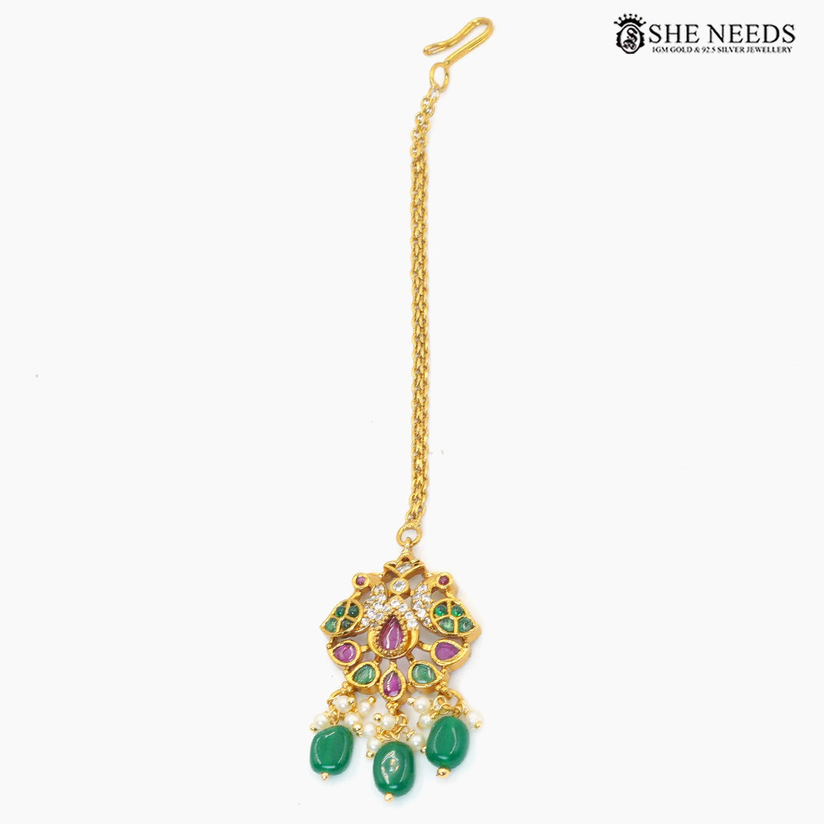 Gold-plated peacock-inspired maang tikka with green bead drops, ruby and white stone detailing, pearls and intricate traditional design|She Needs Jewellery

