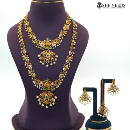 Peacock Lakshmi Pearl antique gold layered necklace set featuring short and long necklaces, matching earrings and maang tikka with colourful stones and pearl drops|She Needs Jewellery