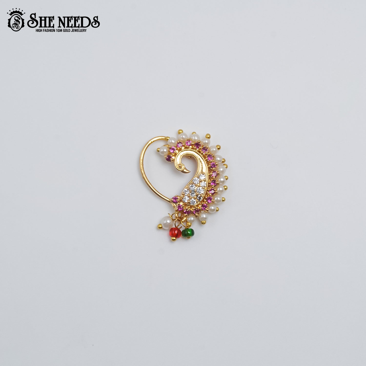 Gold-plated paisley nose pin featuring sparkling CZ stones, pink stone accents, pearl embellishments, and red-green bead drops on a white background 
|She Needs Jewellery