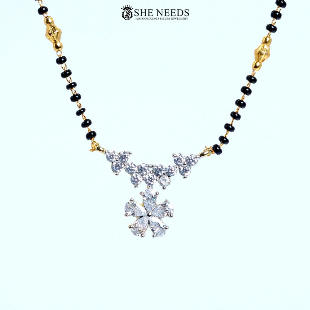 Close-up of Pushpanjali Gold Plated AD Floral Mangalsutra showcasing an American Diamond floral pendant with butterfly-inspired vine accents and black bead chain.|She Needs Jewellery
