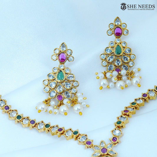 Close-up of Pushparaga Gold Plated American Diamond Pearl Jhumka Earrings featuring floral design with ruby, green, and white stones finished with elegant pearl drops.|She Needs Jewellery
