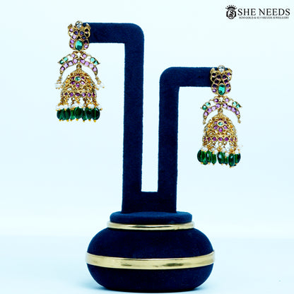 Pair of Pushpika Antique Gold Floral Arch Temple Jhumka Earrings with floral arch motif, antique gold finish, ruby-colored stones, emerald-colored stones, pearls and green bead drops.|She Needs Jewellery

