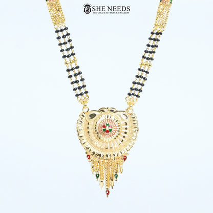 Close-up of Rajeshwari Gold Plated Traditional Mangalsutra showcasing an intricately crafted circular pendant with red and green enamel accents and black bead chain. | She Needs Jewellery