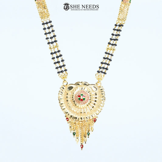 Close-up of Rajeshwari Gold Plated Traditional Mangalsutra showcasing an intricately crafted circular pendant with red and green enamel accents and black bead chain. | She Needs Jewellery