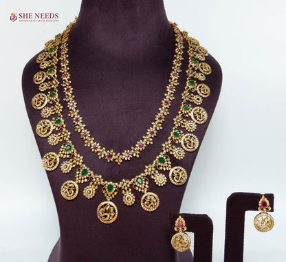 Royal Antique Lakshmi Long Haram Necklace Set with Lakshmi Coin Motifs, Ruby and Emerald Stones, Matching Earrings, and Antique Gold Finish