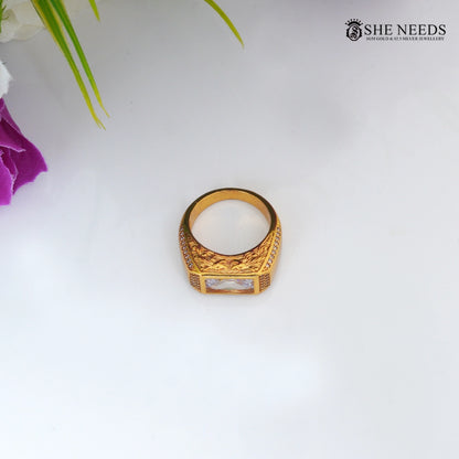 Gold-tone men's ring featuring a rectangular-cut CZ centerpiece, sparkling side stones, and intricate engraved detailing on the band.|She Needs Jewellery
