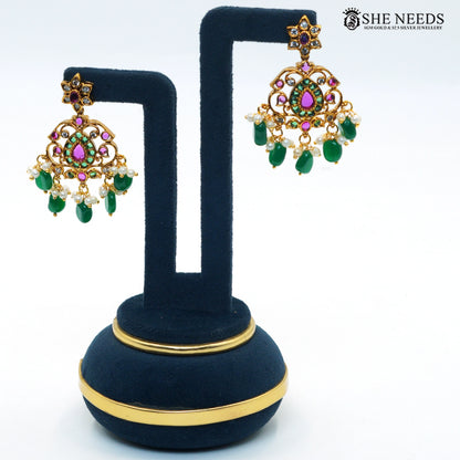Pair of royal gold-toned chandelier earrings with green emerald-style stones, ruby accents, white stones and pearl bead drops|She Needs Jewellery
