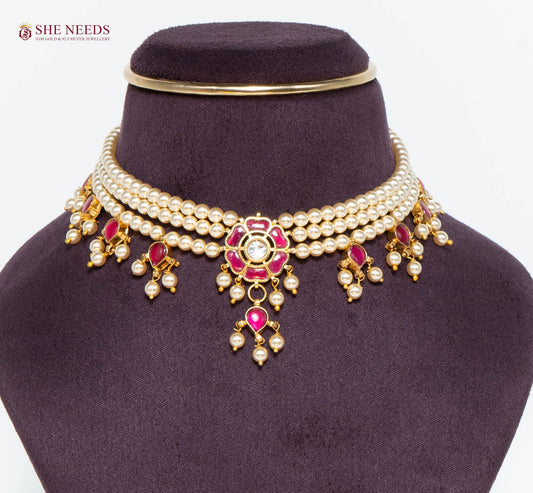 Royal gold pearl choker necklace featuring pink stones, floral centerpiece, layered pearl strands, and pearl drop charms.|She Needs Jewellery
