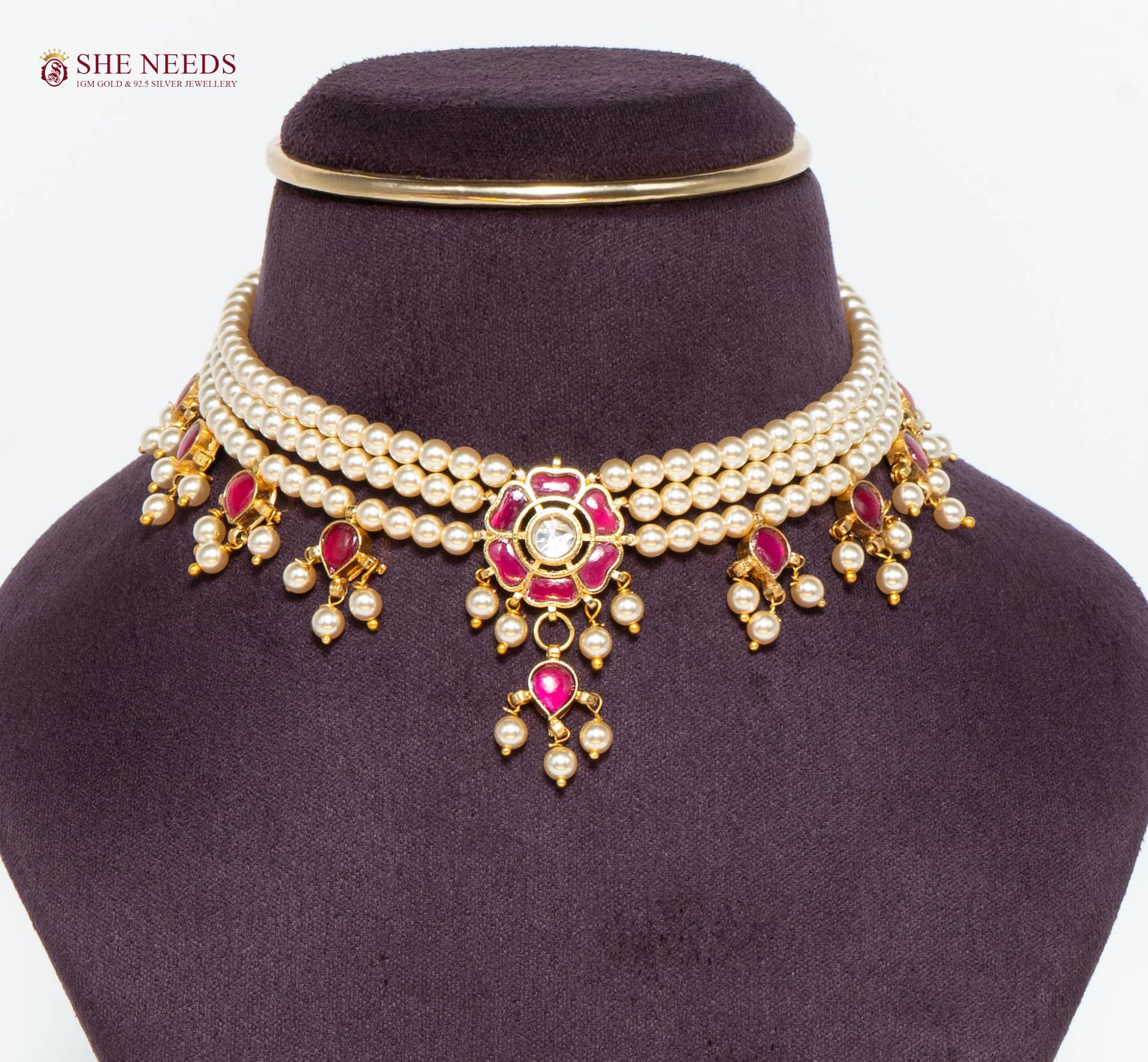 Royal gold pearl choker necklace featuring pink stones, floral centerpiece, layered pearl strands, and pearl drop charms.|She Needs Jewellery
