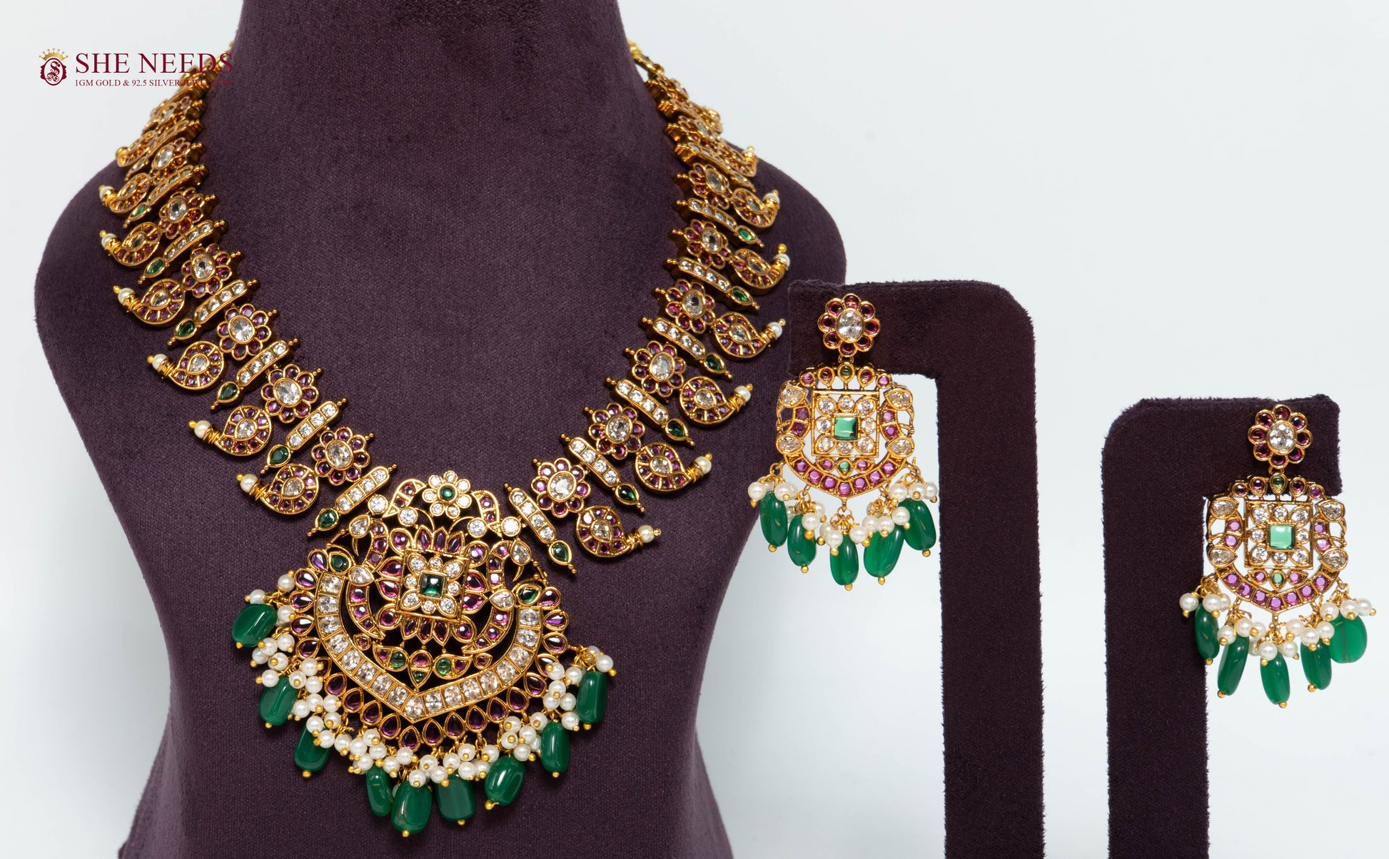 Royal gold temple necklace set with green bead drops, American Diamond stones, pink stone accents, pearl detailing, and matching earrings.|She Needs Jewellery
