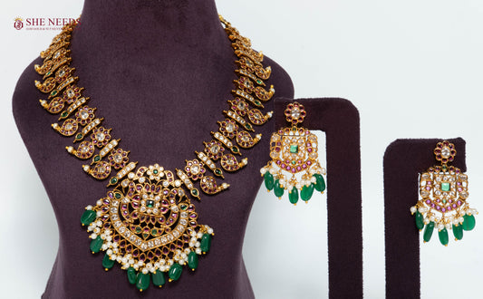Royal gold temple necklace set with green bead drops, American Diamond stones, pink stone accents, pearl detailing, and matching earrings.|She Needs Jewellery
