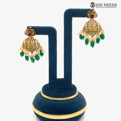 Pair of traditional Lakshmi chandelier earrings with emerald green stones, ruby accents, sparkling white stones and pearl drops|She Needs Jewellery