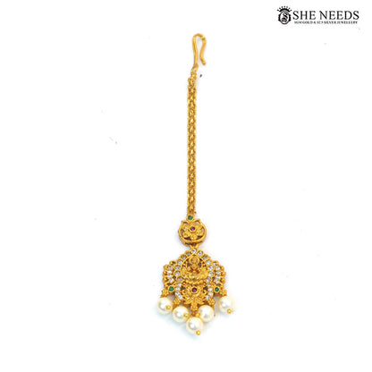 Traditional Lakshmi maang tikka with ruby, green stones, sparkling white stones and pearl drops|She Needs Jewellery
