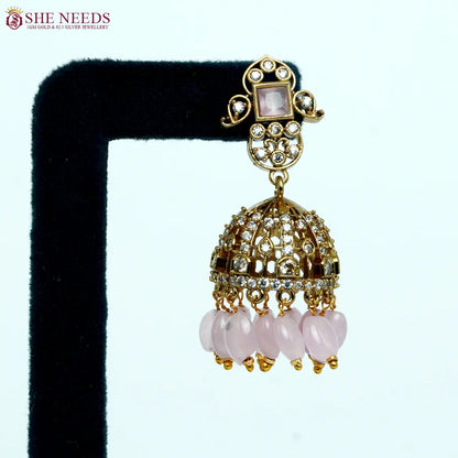 Gold-tone dome jhumka earrings with sparkling white stones, blush pink square center stones, and light-pink bead drops, ideal for weddings and festive occasions. | She Needs Jewellery
