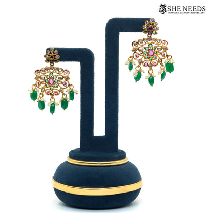 Pair of royal gold-plated statement earrings with green emerald-style bead drops, ruby and white stone detailing and traditional temple design|She Needs Jewellery
