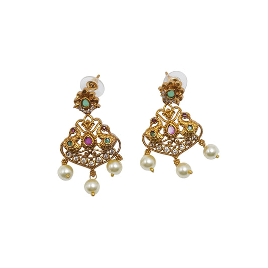 Antique gold earrings featuring peacock-inspired motifs, sparkling kundan stones, ruby-pink and emerald-green accents, intricate filigree craftsmanship, and pearl drop danglers.|She Needs Jewellery
