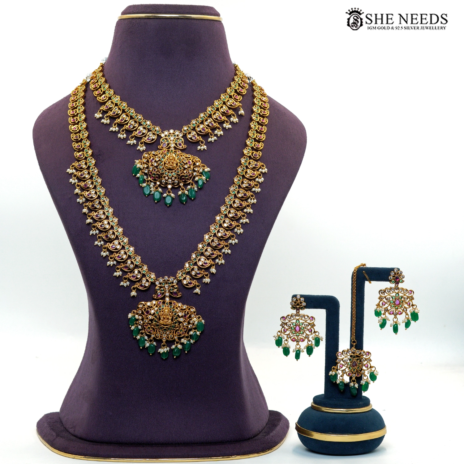 Royal gold-plated peacock temple necklace set featuring green emerald-style stones, ruby accents, white stones, pearl drops and matching earrings|She Needs Jewellery
