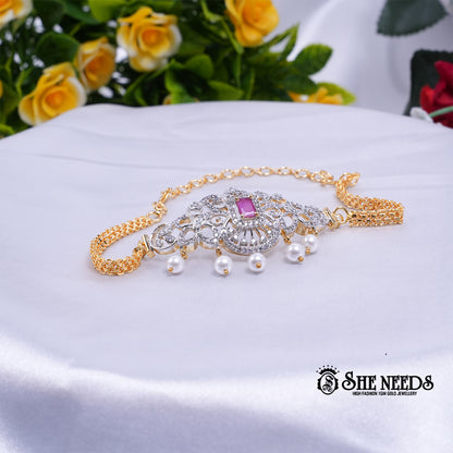 Dual-tone Royal Pearl Stone Baju Band Set featuring sparkling CZ stones, a ruby-pink center stone, intricate floral filigree detailing, and elegant pearl drop accents with an adjustable chain.|She Needs Jewellery
