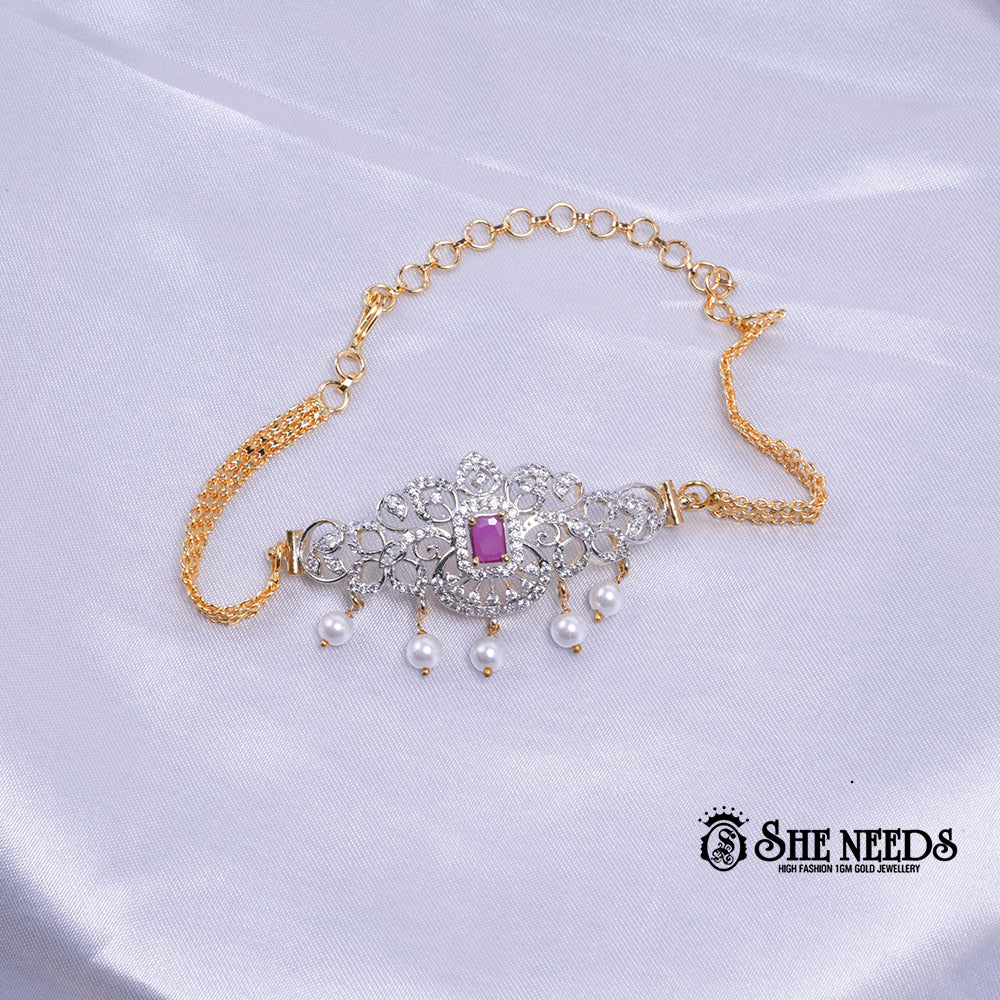Dual-tone Royal Pearl Stone Baju Band Set featuring sparkling CZ stones, a ruby-pink center stone, intricate floral filigree detailing, and elegant pearl drop accents with an adjustable chain.|She Needs Jewellery
