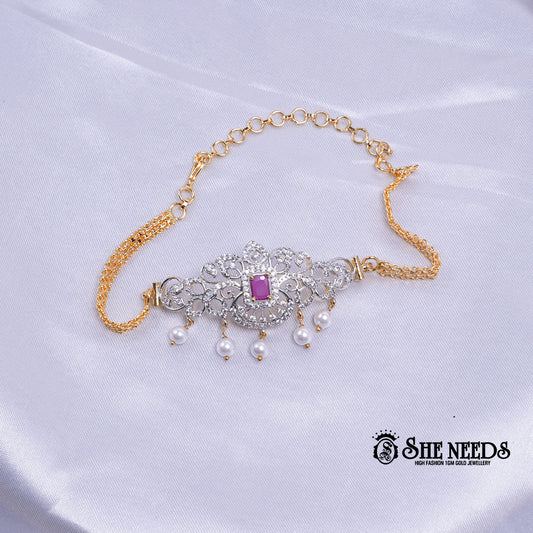 Dual-tone Royal Pearl Stone Baju Band Set featuring sparkling CZ stones, a ruby-pink center stone, intricate floral filigree detailing, and elegant pearl drop accents with an adjustable chain.|She Needs Jewellery
