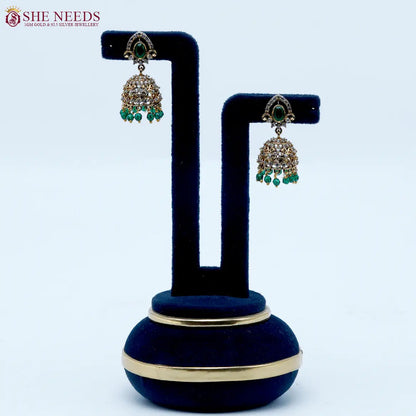 Royal Stone Antique Emerald Green Jhumka Earrings featuring sparkling American Diamonds, antique gold detailing, emerald green stone, and green crystal bead drops.|She Needs Jewellery