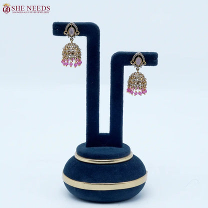 Royal Stone Antique Light Pink Jhumka Earrings featuring sparkling American Diamonds, antique gold detailing, a light pink oval stone, and light pink crystal bead drops.|She Needs Jewellery
