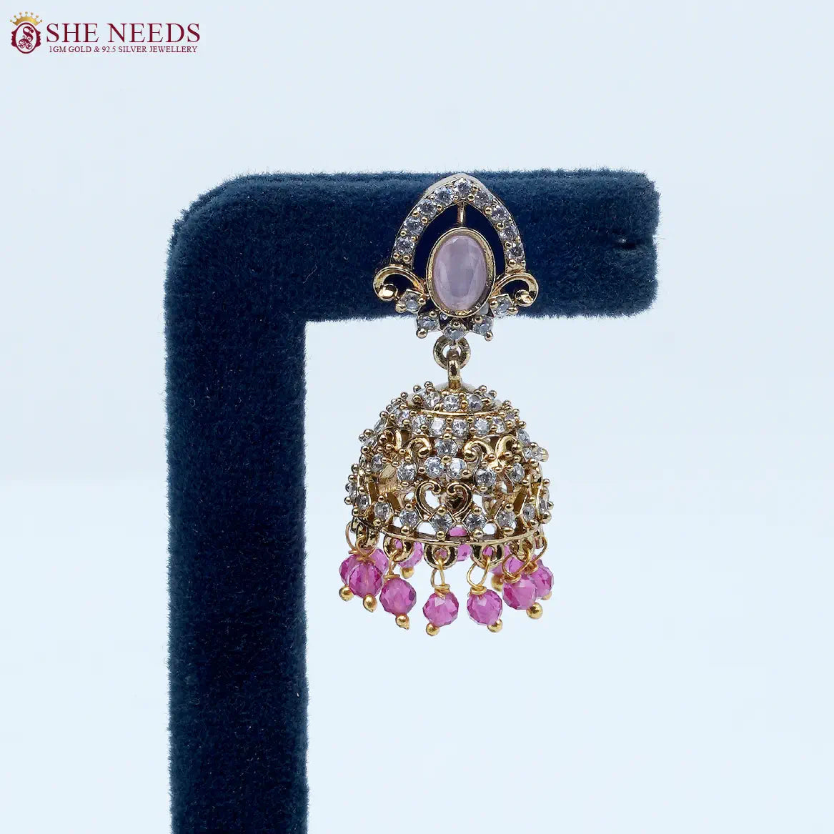 Royal Stone Antique Light Pink Jhumka Earrings featuring sparkling American Diamonds, antique gold detailing, a light pink oval stone, and light pink crystal bead drops.|She Needs Jewellery
