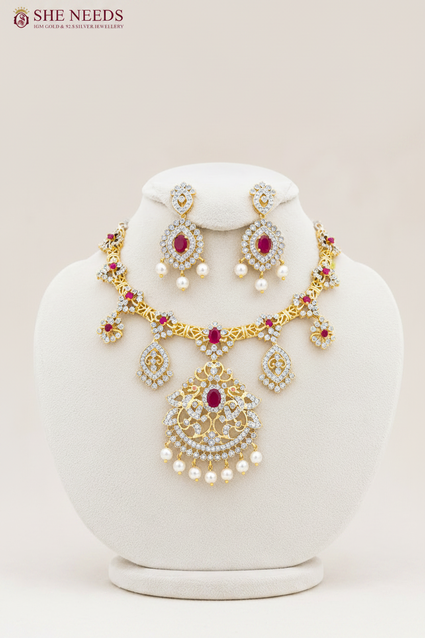 Elegant ruby pink AD stone bridal necklace set with pearl drop earrings in premium gold finish displayed on white mannequin.
