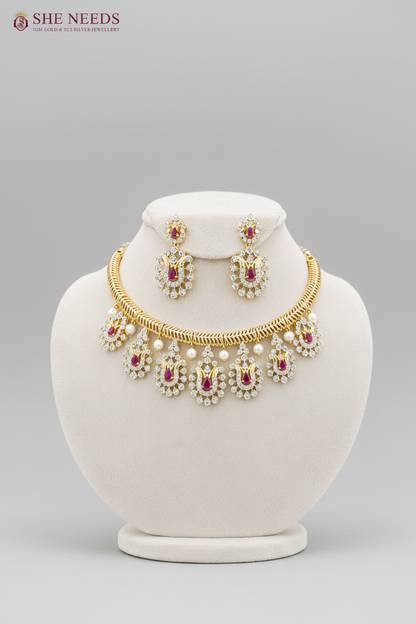 Elegant ruby pink AD stone gold plated choker necklace set with pearl accents and matching earrings displayed on white mannequin.