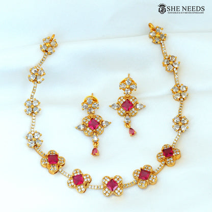Ruby stone floral gold-plated necklace with matching earrings arranged on a white background|She Needs Jewellery
