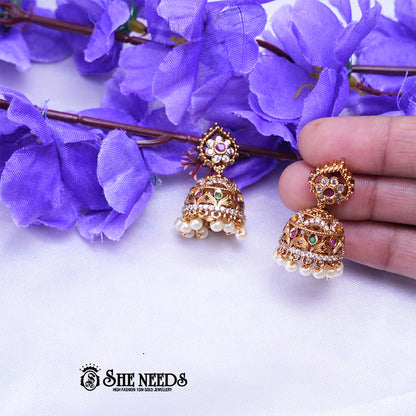 Antique temple jhumka earrings with CZ stones and pearl drops in intricate traditional Indian design