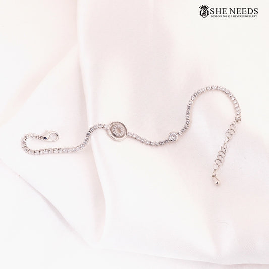 Silver CZ wave bracelet featuring sparkling cubic zirconia stones, a circular crystal centerpiece, and an adjustable extension chain displayed on a white fabric background. |She Needs Jewellery
