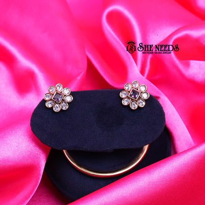 Square Purple Floral CZ Stud Earrings featuring a square-cut purple center stone surrounded by sparkling cubic zirconia petals in a floral design with a gold finish.|She Needs Jewellery

