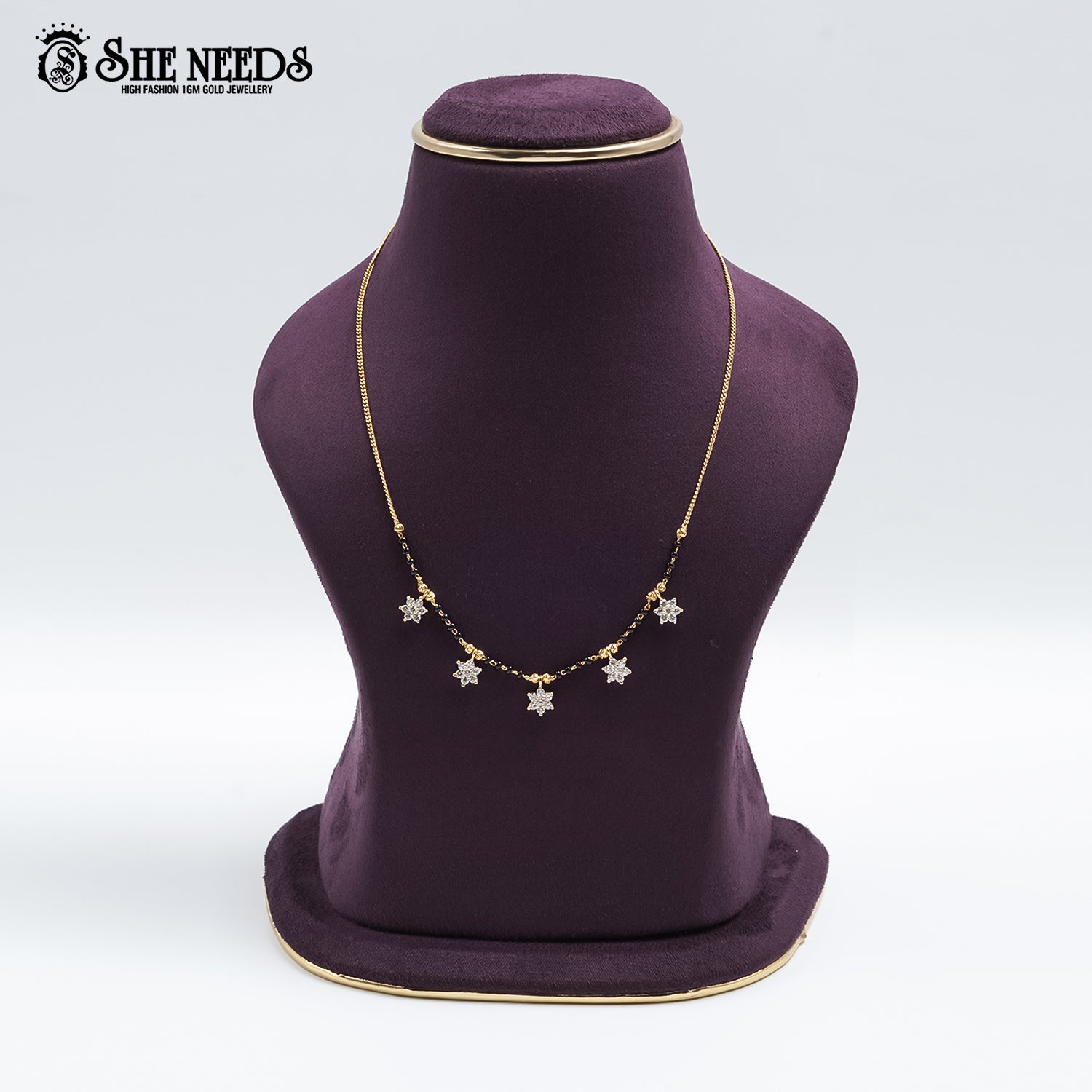 Gold-tone Star Charm Mangalsutra featuring sparkling CZ star-shaped charms, traditional black bead detailing, and a delicate chain design displayed on a jewelry bust.