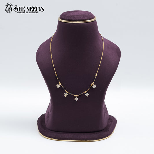 Gold-tone Star Charm Mangalsutra featuring sparkling CZ star-shaped charms, traditional black bead detailing, and a delicate chain design displayed on a jewelry bust.