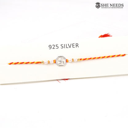 Swastik Rakhi with 925 silver centerpiece, pearl beads and red-yellow braided Rakhi thread|She Needs Jewellery
