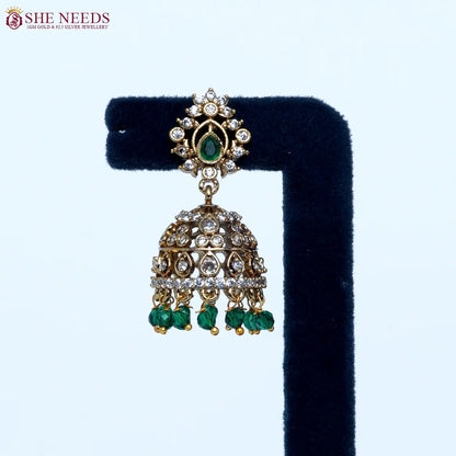 Gold plated traditional jhumka earrings with emerald green bead drops and sparkling zircon stones for women|She Needs Jewellery