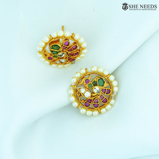 Pair of Vamika Antique Gold Pearl Floral Stud Earrings featuring pearl border, floral swirl design, ruby-colored stones, emerald-colored stones and American Diamonds.|She Needs Jewellery
